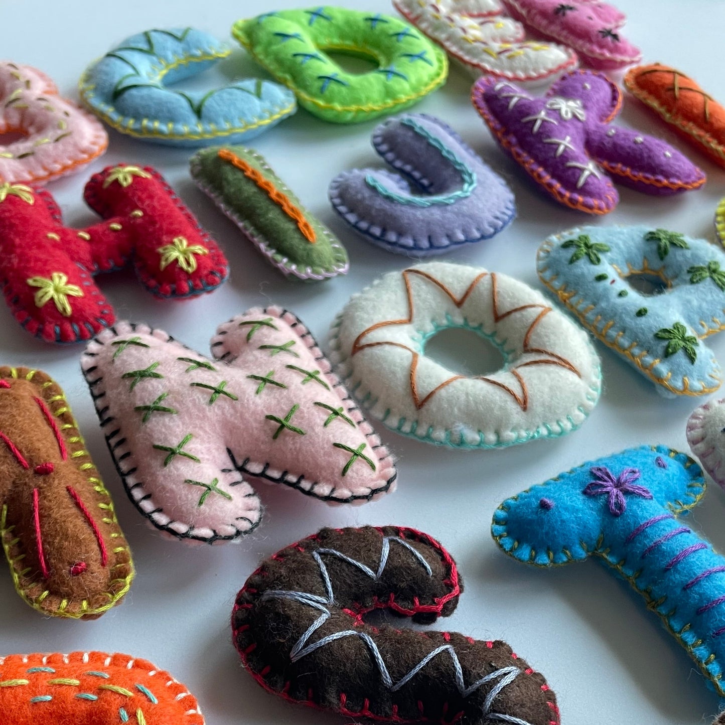 Colorful felt letters alphabet  and shapes on a white background