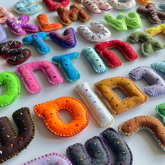 Colorful handmade felt letters on a white background
