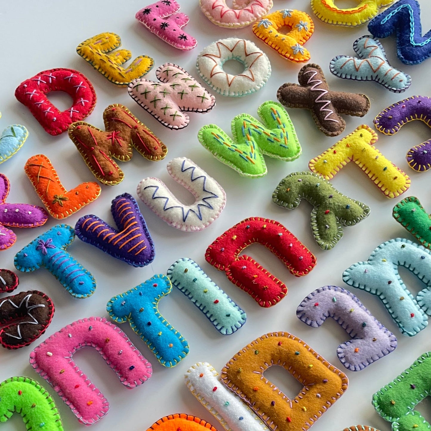 Colorful Hebew and Latin alphabet letters made of felt on a white background