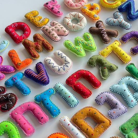 Colorful Hebew and Latin alphabet letters made of felt on a white background