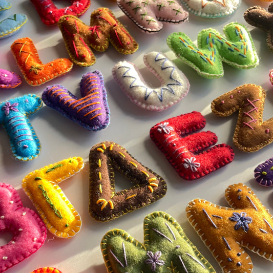 Colorful handmade fabric letters on a white background