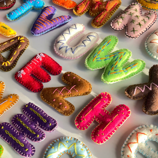 Colorful handmade fabric letters on a white background