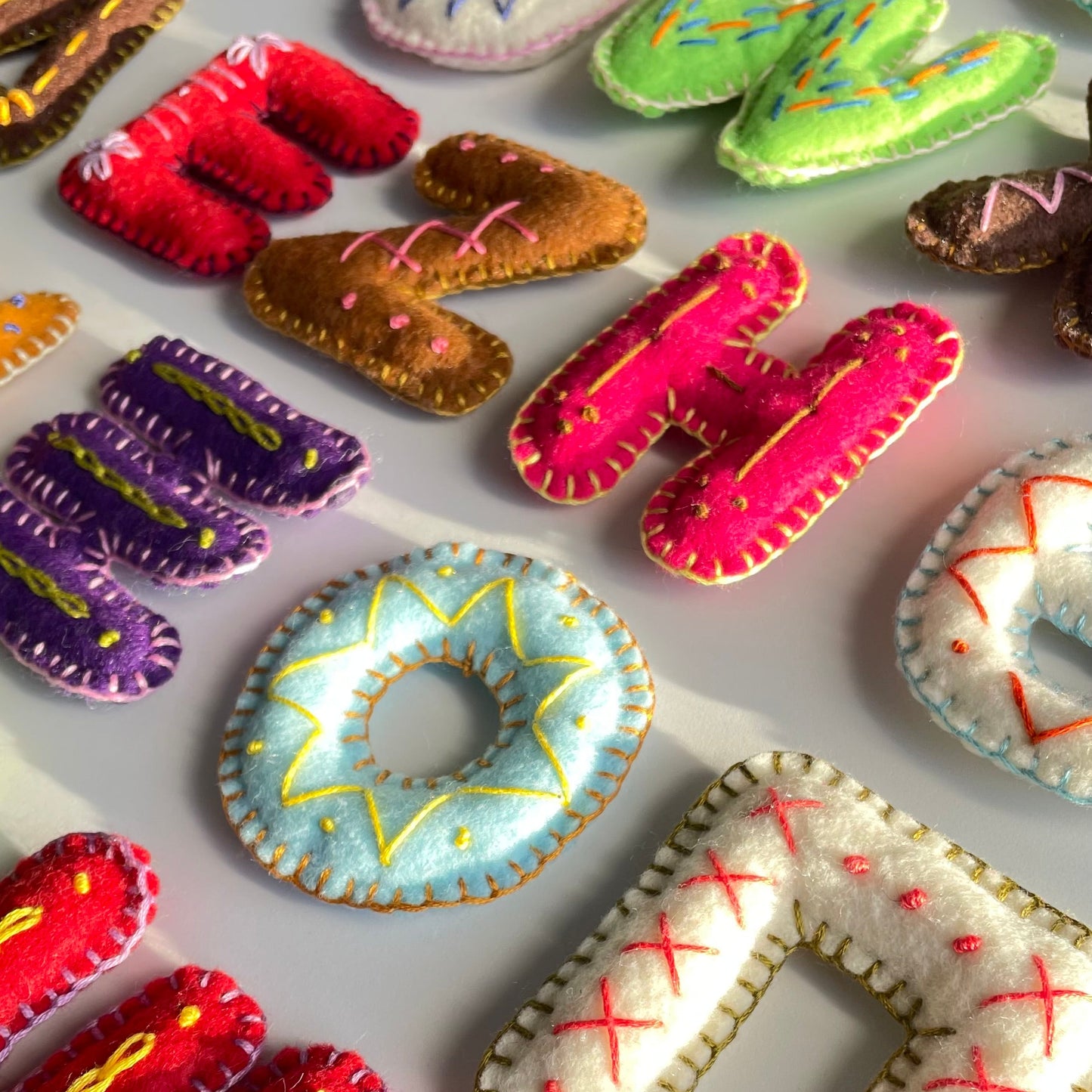 Colorful fabric letters and shapes on a white background